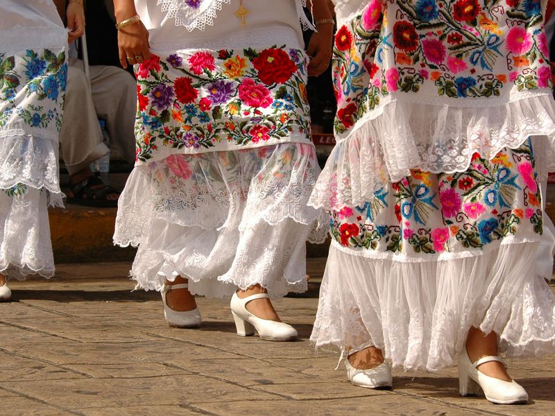 Women in traditional Mexican dresses dancing.