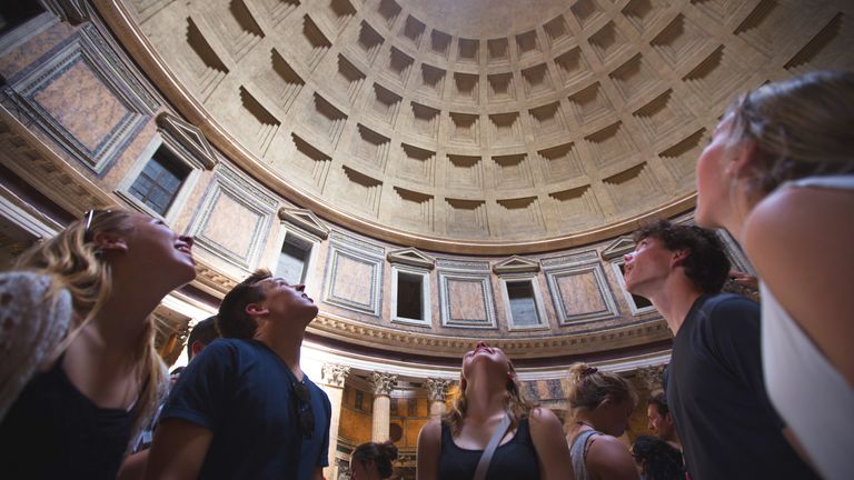 Young adults marvel at the Pantheon's dome in Rome.