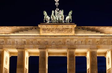 The Brandenburg Gate in Berlin, Germany, lit up at night.