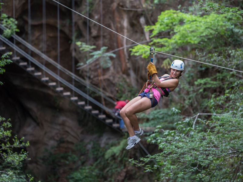 Young woman ziplining through a forest in Costa Rica