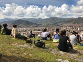 Group of young adults overlooking Cusco, Peru from a hillside.