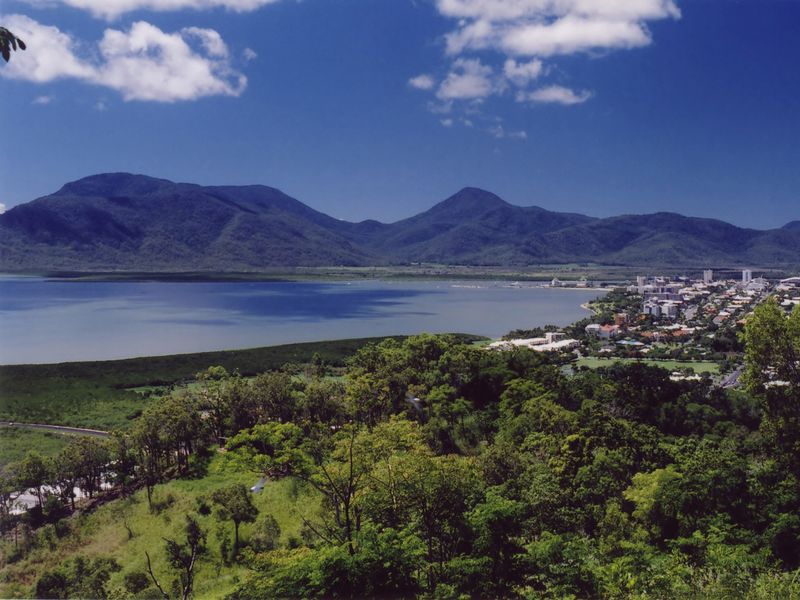 Panoramic view of Cairns, Australia, with mountains, bay, and city skyline.