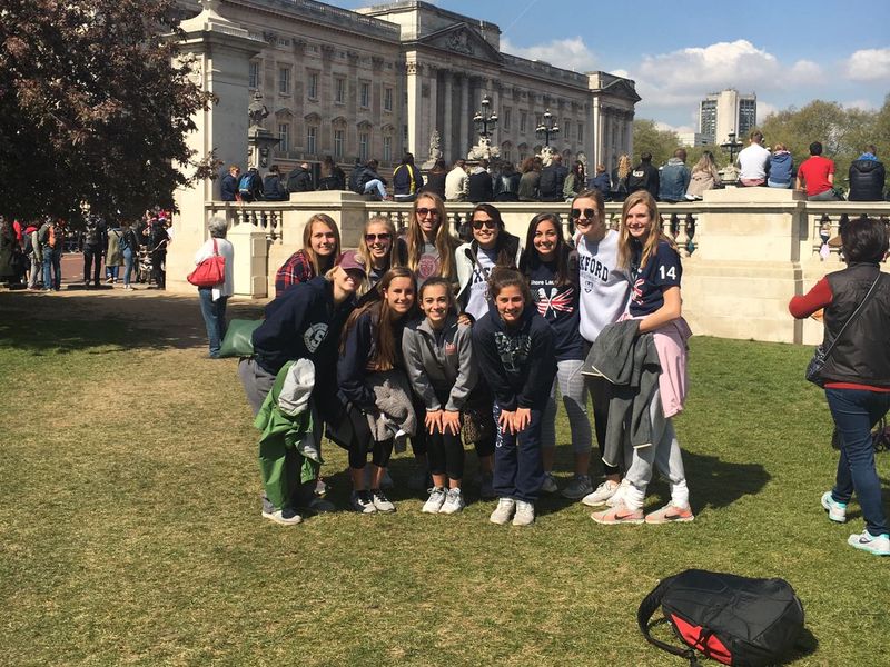 A group of teenage girls pose in front of Buckingham Palace in London.