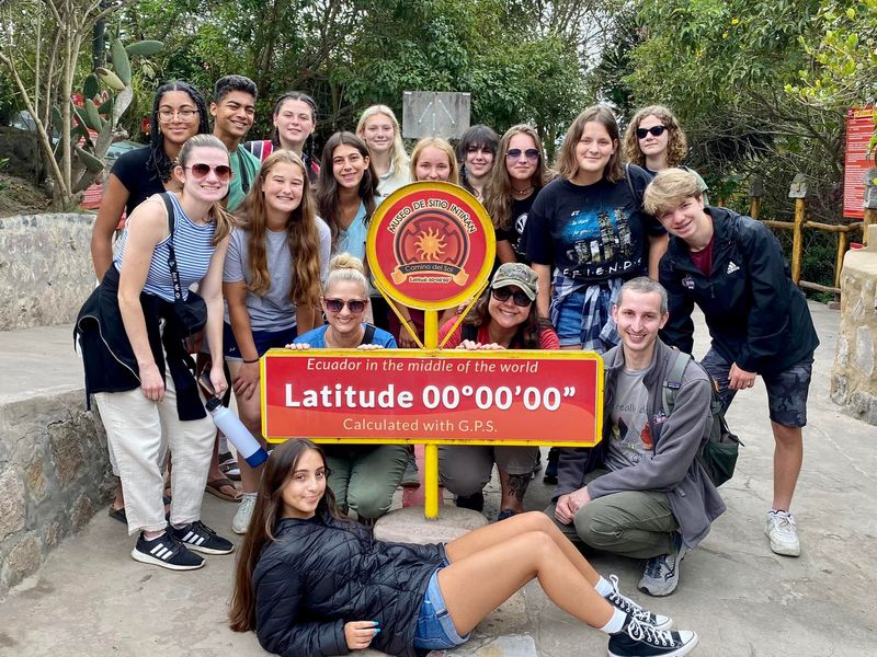 Group photo at the Mitad del Mundo monument in Quito, Ecuador, marking the equator.