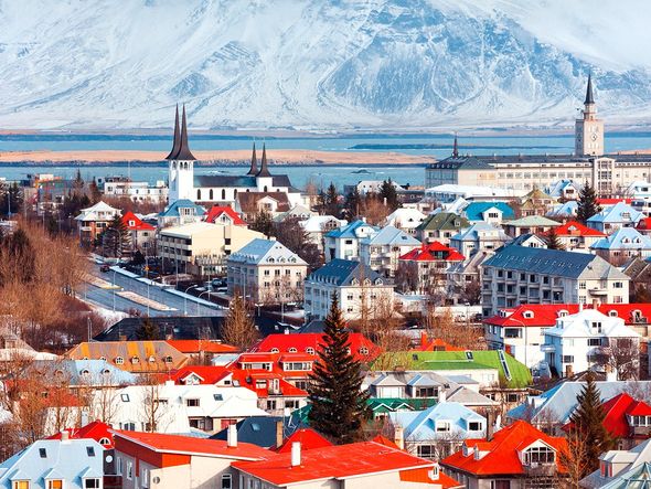 Colorful houses with snow-capped mountains in the background in Reykjavik, Iceland