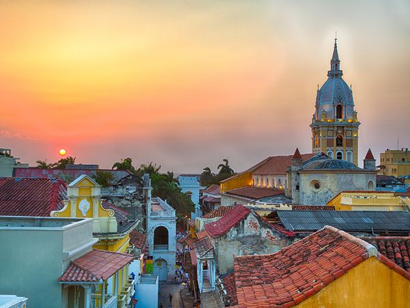 Sunset over the colorful colonial buildings and church tower of Cartagena, Colombia.