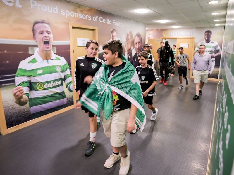 A group of fans walking down a hallway at Celtic Park.