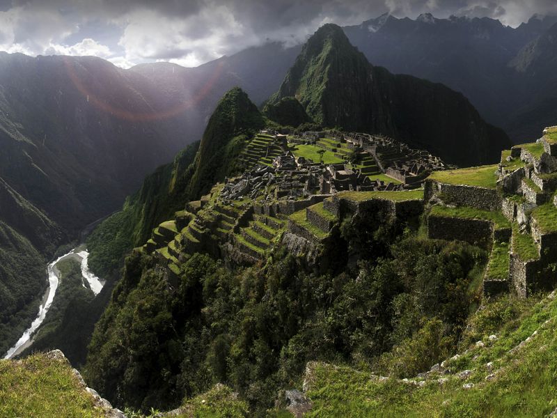 A panoramic view of the Machu Picchu ruins in Peru, with its terraced structures and surrounding mountains.