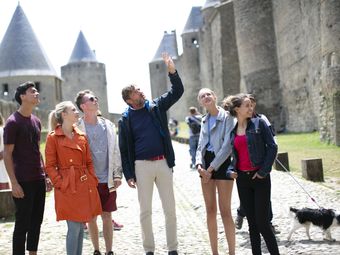 Group of tourists admiring the Cité de Carcassonne, a medieval citadel in France.