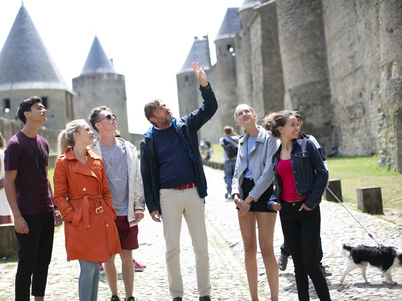 Group of tourists admiring the Cité de Carcassonne, a medieval citadel in France.