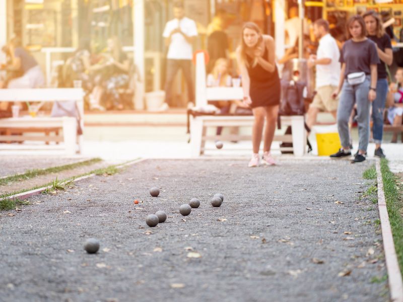 People playing Petanque in a park or recreational area.