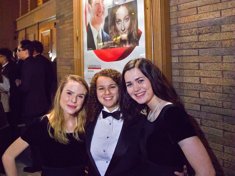 Three young adults dressed for a night at Carnegie Hall in New York City.