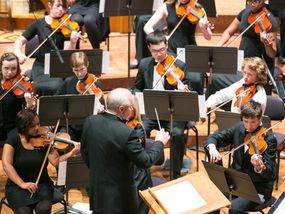 A youth orchestra performing on stage.