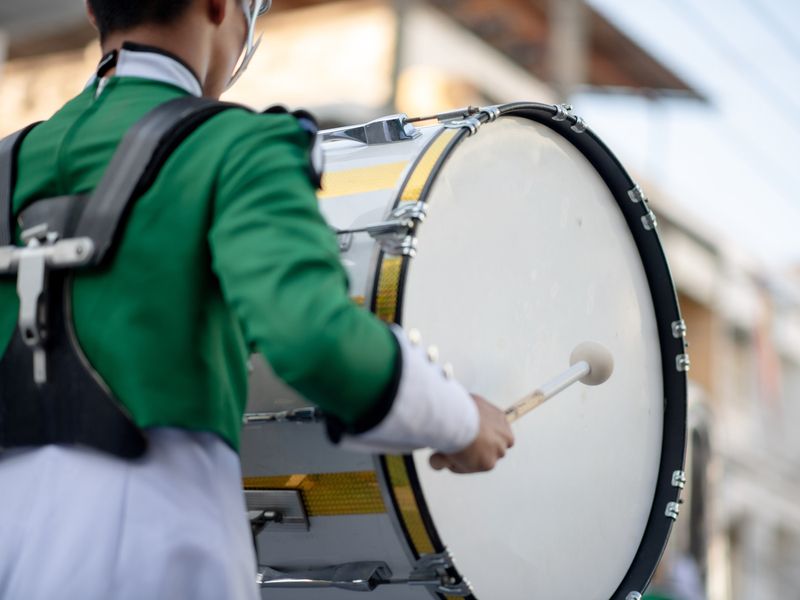 Marching band member playing a bass drum