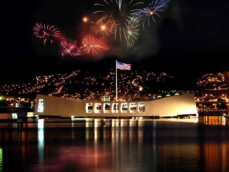 The USS Arizona Memorial at night with fireworks.