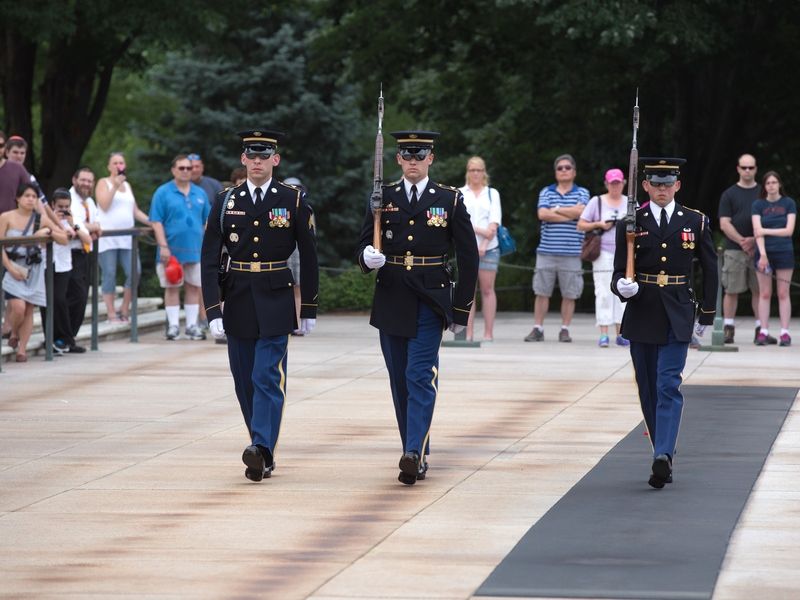 Three soldiers marching in unison at Arlington National Cemetery.