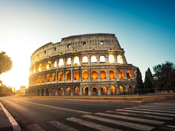 The Colosseum in Rome, Italy bathed in the golden light of sunrise.