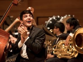 Young Adult Male Musician in Tuxedo Clapping During Orchestra Concert