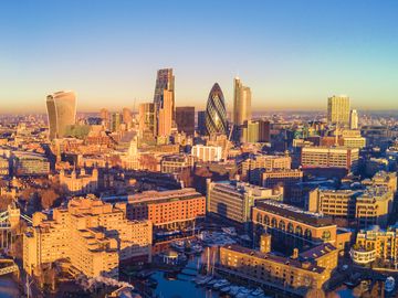 Aerial view of London skyline at sunset with Tower Bridge.