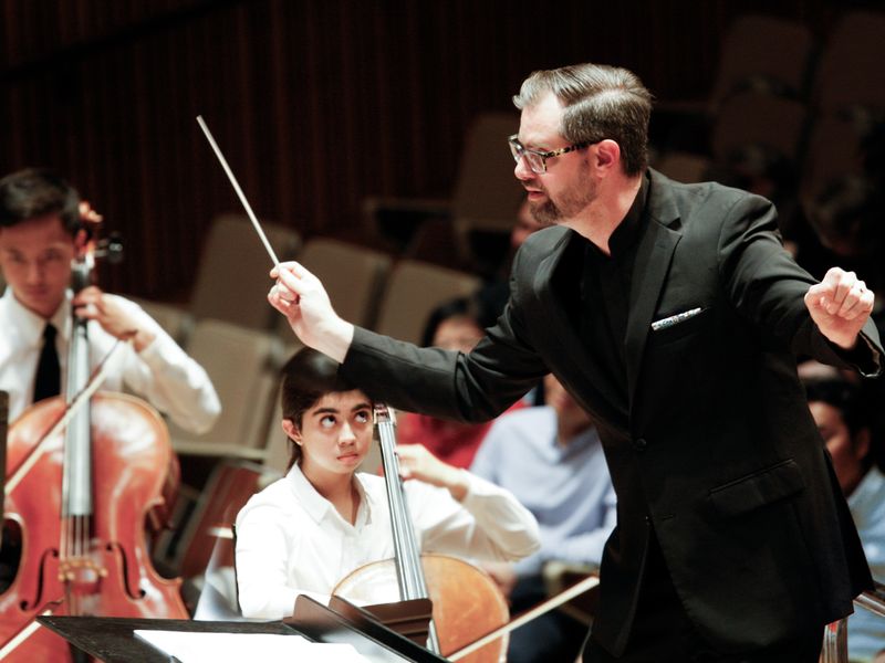 A conductor leads a youth orchestra.