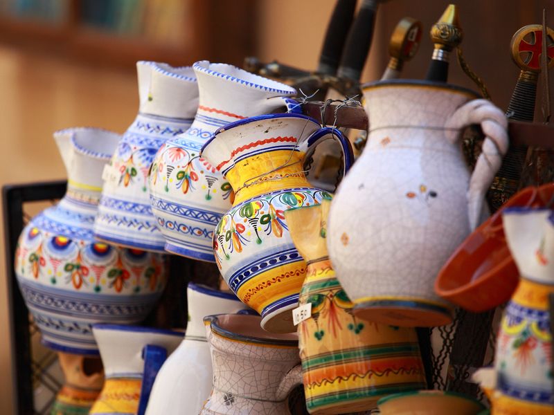 Colorful ceramic pitchers on display at a Spanish market