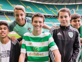 Five teenage boys at Celtic Park stadium in Glasgow, Scotland. Celtic Park is the largest football stadium in Scotland and one of the biggest in the UK, home to Celtic FC. The boys look excited to be there.