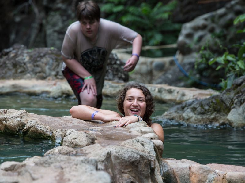 Two teenagers enjoying a natural hot springs pool.