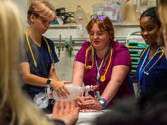 Nursing students practice medical techniques on a simulated patient