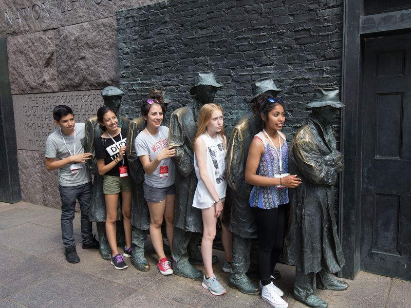 Group of teenagers pose with the statues at the Franklin Delano Roosevelt Memorial