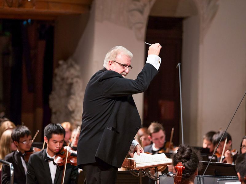 Orchestra conductor leading a performance.