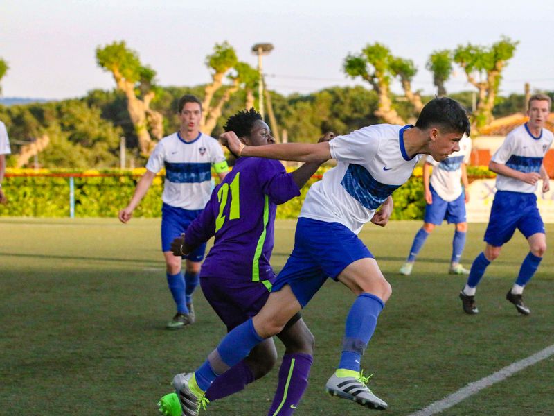 Two young adult soccer players compete for the ball during a game.