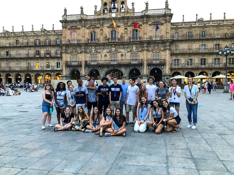 Group of teenagers and young adults posing for a photo in the Plaza Mayor, Salamanca, Spain.